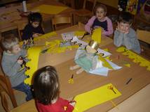 Kindergruppe die rund um einen Tisch bastelt